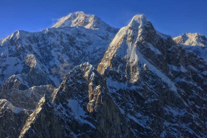 Snow-covered mountain peaks under a clear blue sky.